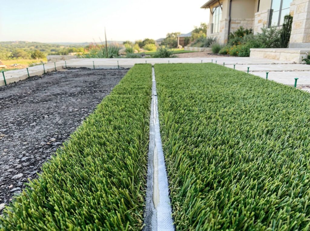 Close-up of artificial turfgrass installation seaming stage before infill for seamless synthetic lawn.