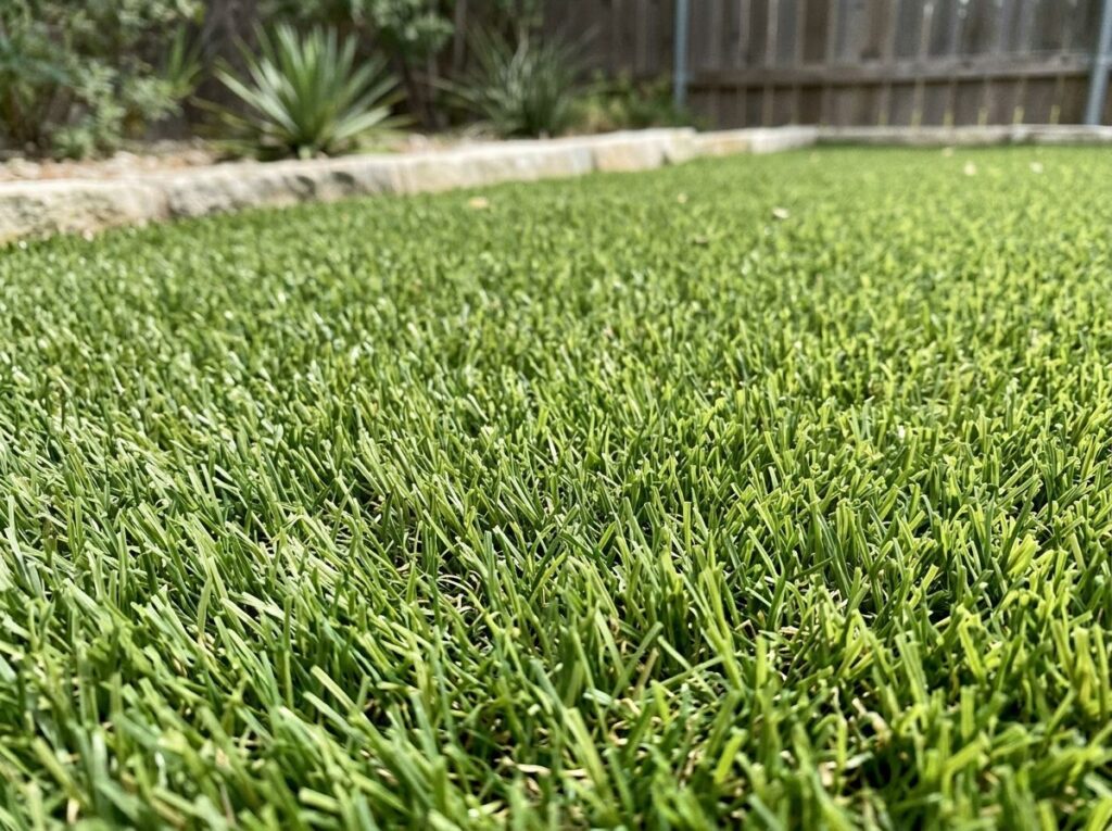 BudgetSaver Green artificial turf installed in a San Antonio, TX backyard, workers laying and securing seams.