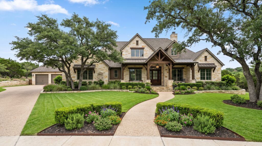 Hill Country limestone home front yard landscape design with xeriscape gravel beds, boulders, and drought-tolerant landscaping
