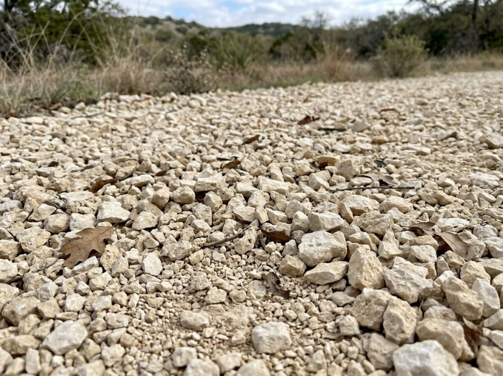 Crushed Limestone ground cover in light gray, crushed stone spread evenly for landscaping paths and beds.