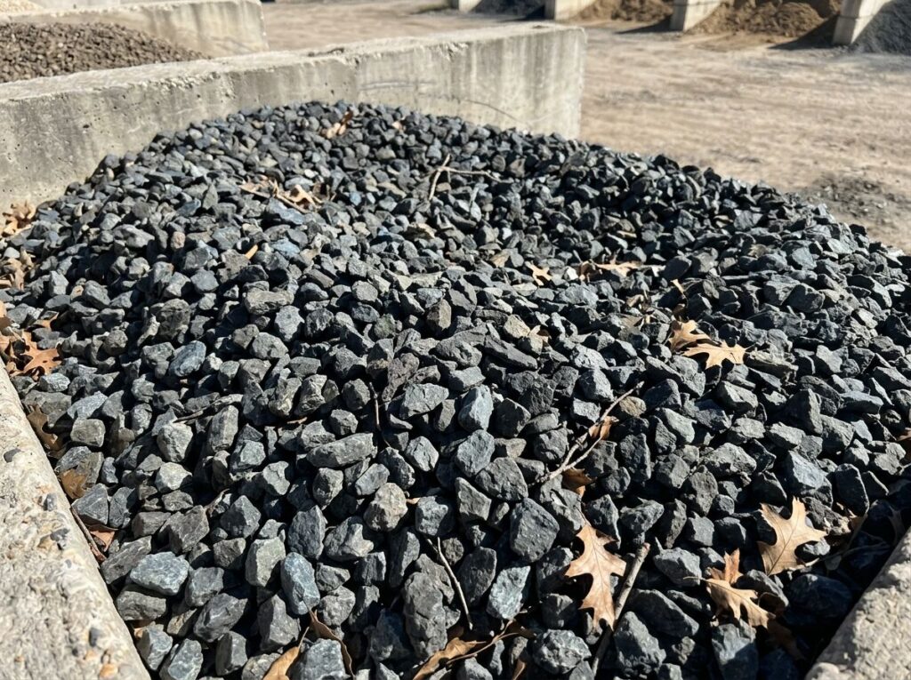 Shadow Stone ground cover of dark gray crushed rock spread in an even layer across a landscape bed.
