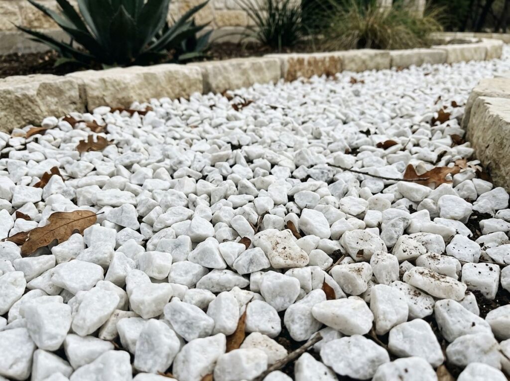 White Quartz Marble ground cover with bright white stone chips spread evenly across a landscape bed.