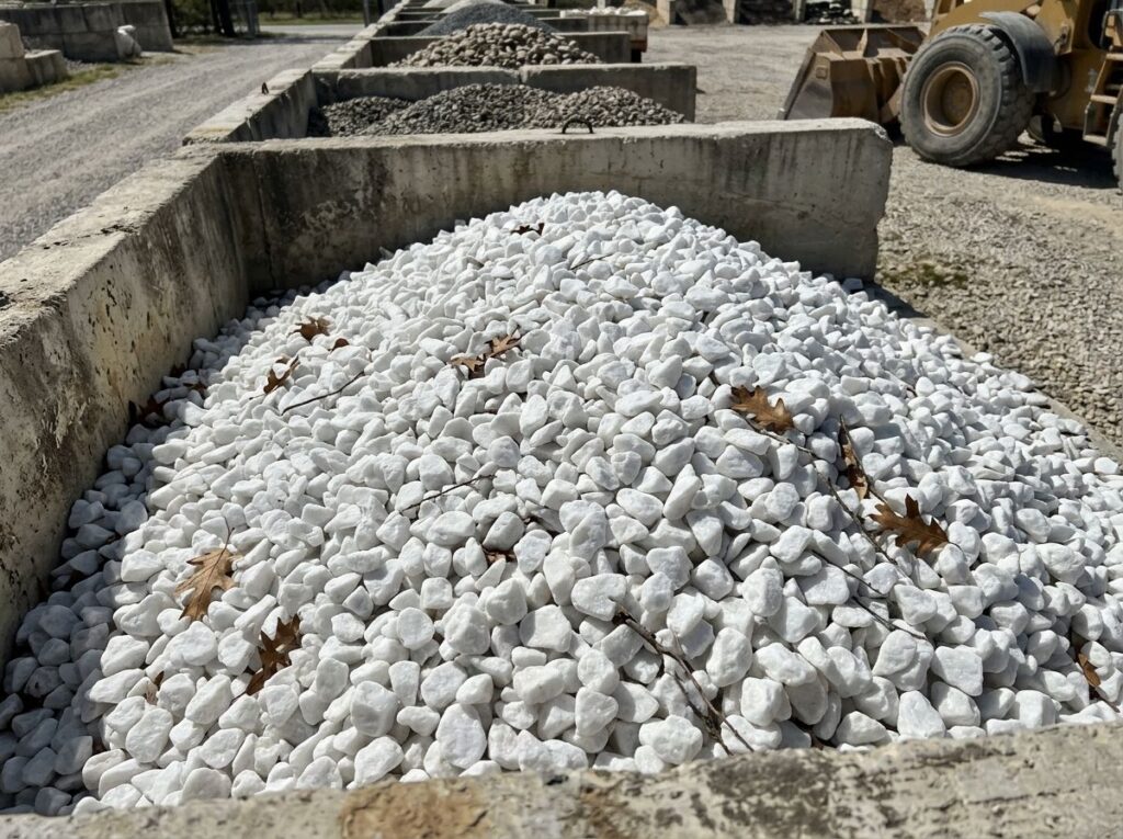 White Quartz Marble ground cover of bright white stone chips spread evenly for a clean landscaping bed.