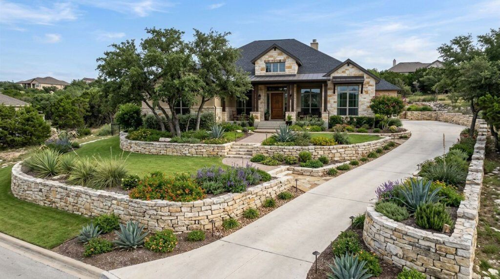 Completed natural stone landscape with boulders, mulch beds, and drought-tolerant plants